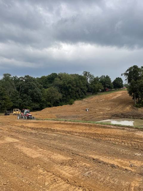Dam grading under a stormy sky