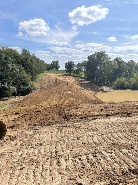 Graded dam top with pond alongside