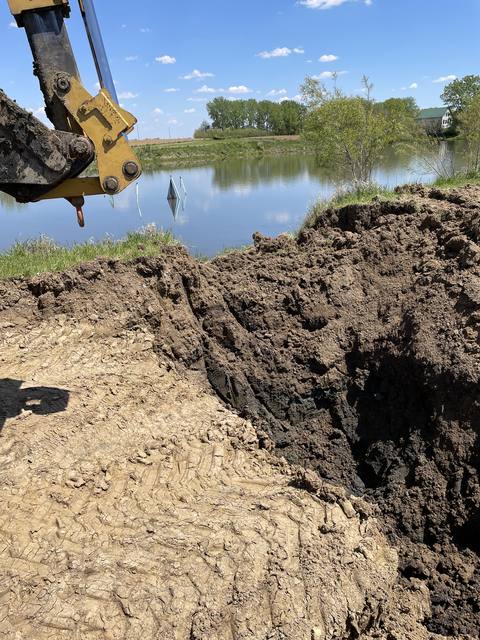 Close view of pond bank excavation next to finished water