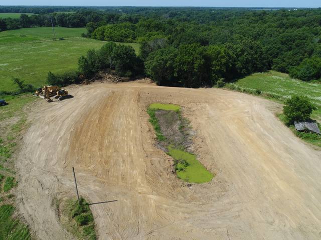 Aerial view of a pond site under construction with equipment